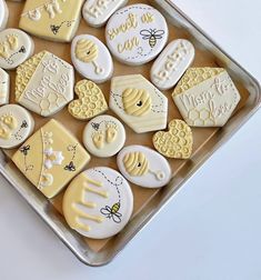 decorated cookies in the shape of bees and honeycombs on a baking sheet with words