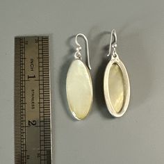 Earrings, Mother of Pearl Ovals on French wires. Sleek, Modern, Simply Classic. 2 ½" long Mother of pearl shell for jewelry refers to the nacre that coats the inside layer of the mollusk shell which is used to form pearls--hence, it's the mother of the pearl. Mother of pearl shell jewelry can include much larger focal pieces than simple pearls since nacre substance takes up a whole shell's interior, offering a larger working surface for carving. In addition to jewelry, mother-of-pearl shell has been used in medieval European, East Asian and Islamic religious art. Starting during the Victorian Era, mother-of-pearl shell began to also be used for clock faces, buttons, jewelry boxes and more. One especially popular use was inlay work, such as the handles of knives and pistols, as well as hist White Oval Earrings With Polished Finish, Silver Shell-shaped Earrings With Pearl Drop, Oval Mother Of Pearl Jewelry For Formal Occasions, Oval Mother Of Pearl Jewelry For Formal Events, Silver Oval Pearl Earrings For Pierced Ears, Oval Pearl Drop Jewelry, Elegant Shell-shaped Pearl Earrings In Mother Of Pearl, Silver Pearl Earrings With Mother Of Pearl, Oval Mother Of Pearl Jewelry With Polished Finish