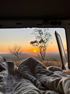 the sun is setting in the distance as seen from inside a vehicle with an open window