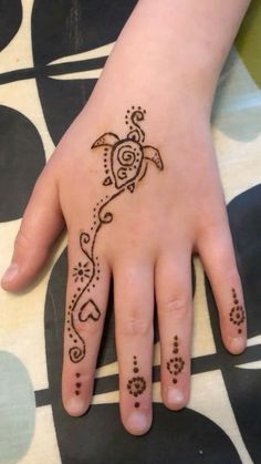 a child's hand with a henna tattoo on it