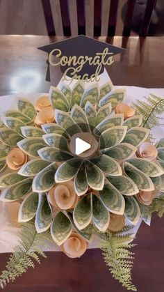 a graduation cap made out of money sitting on top of a table with the words congrats card