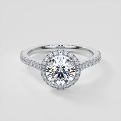 a white gold engagement ring with an oval halo setting and pave diamonds on the band