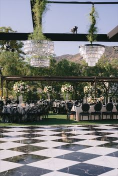 a black and white checkered floor with chandeliers hanging from it's ceiling