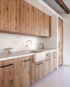 a kitchen with wooden cabinets and white counter tops, along with a sink in the center