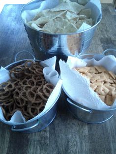 three metal buckets filled with food on top of a wooden table