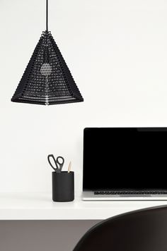 a laptop computer sitting on top of a desk next to a pen and pencil holder