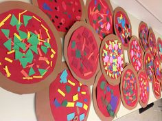 paper plates are lined up on the floor with different shapes and colors painted on them