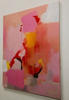 a painting hanging on the wall in an art gallery, with pink and yellow colors