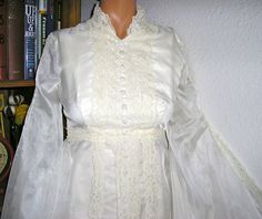 a mannequin wearing a white dress with long sleeves