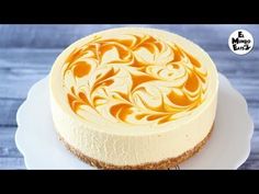 a white plate topped with a cheesecake covered in orange swirls and frosting