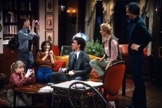 the cast of friends are sitting around in their living room