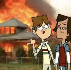 two people standing in front of a house on fire