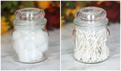 two jars filled with cotton swabs on top of a table