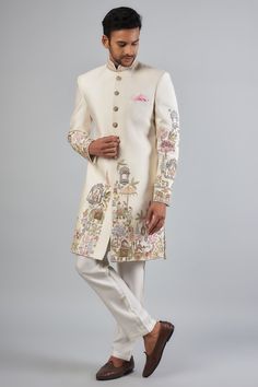 Featuring an ivory sherwani in Malai satin base with embroidered resham thread work. It is paired with heavy tensile dyed cotton pants. Perfect for a wedding or engagement ceremony.  (you can make simple kurta also for occation) Inclue:- (i) kurta (top) with inner cotton layer (ii) pant/chudidar white color (bottom) Men Sherwani Designs Style, Transitional Season Embroidered Raw Silk Sherwani, Traditional Cream Sherwani With Embroidery, Traditional Cream Embroidered Sherwani, Traditional Embroidered Cream Sherwani, Embroidered Raw Silk Sherwani Straight Kurta, Traditional Cream Embroidered Bandhgala, Embroidered Beige Sherwani For Eid, Festive Cream Embroidered Sherwani