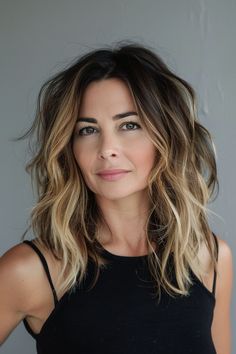 Transitioning from dark roots to lighter ends, this medium-length hair with ombre coloring offers a trendy and fashionable look for women over 40. Medium Trendy Haircuts For Women, Edgy Hair For Women Over 40, Medium Length Haircut For Women In 40s, Trendy Haircuts 2024, Hair Color For 40 Year Old Women, Balayage Hair Medium Length, Medium Balayage Hair, 40 Year Old Hair Styles, Medium Length Hair Women