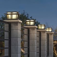 four lights are lit up on the concrete pillars