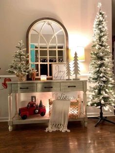 a white christmas tree sitting on top of a wooden table in front of a mirror