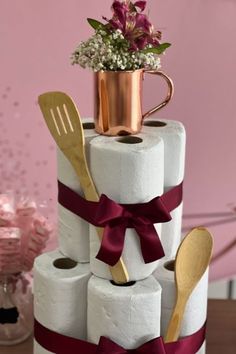 a stack of toilet paper with utensils and flowers on top