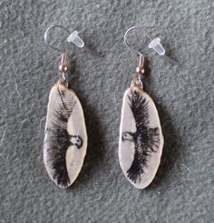 These enchanting earrings are made of deer antler with a Bald Eagle on a natural antler slices hand painted on each one. The Eagle was seen as a source of wisdom and strength for the First Peoples and was held in high respect for his keen vision and power of flight. Eagles were respected for their courage and their feathers and talons were highly treasured and precious. These are a unique, one of a kind gift or addition to YOUR collection. They are approximately 1 1/2 inch long X 1/2  inch and have a lot of texture from the antler. They are very light to wear! The painting is protected with a water proof sealer that has a glass like finish. The Artist (me)has signed and dated the back of each earring. They are on Surgical Stainless Steel fishhook earrings with soft rubber stoppers and pack Rustic Hand Painted Jewelry For Gifts, Rustic Hand Painted Jewelry Gift, Nature-inspired Hand Painted Drop Earrings, First Peoples, Deer Antler, The Eagle, Fish Hook Earrings, Deer Antlers, Native Art