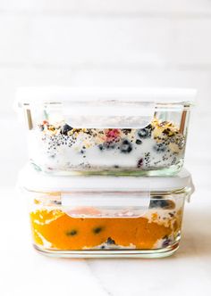 two glass containers filled with food sitting on top of a white counter next to each other