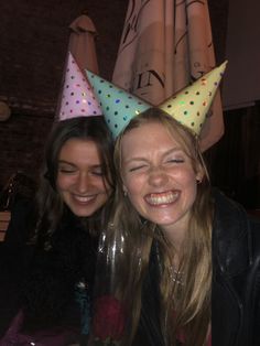 two women wearing party hats at a table