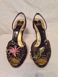 Pre-owned Fendi monogram ENAMEL FLOWER shoes in a size 38.5 or an 8 1/2. This shoe seems to run true to size.  About a 4.25" heel with a .75" platform, so more like a 3 1/2" heel.  VERY UNIQUE!  Shoes are in excellent condition and were very lightly used. These shoes look like they're brand-new, with the exception of the stuffs on the bottom of the shoes where they were worn a few times. Please see my other auctions for the matching handbag, which I have in four different styles and sizes. eBay Luxury Vintage Open Toe Sandals, Designer Luxury Brown Heels, Iconic Heels, Vintage Fendi Runway, Heels Fendi, Designer Brown Sandals With 4-inch Heel, Fendi Monogram, Monogram Shoes, Manolo Blahnik Sandals