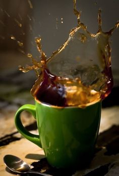 a green cup filled with liquid on top of a table