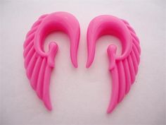 two pink plastic angel wings on a white background