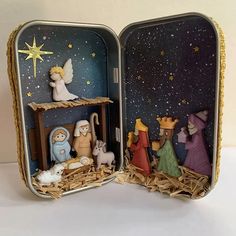 an open tin box with nativity scene inside