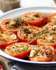 a white bowl filled with sliced tomatoes on top of a wooden table