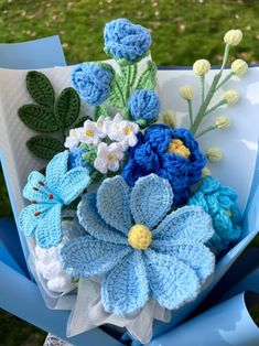 a bouquet of crocheted flowers sitting on top of a blue chair