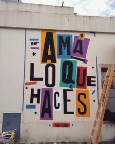 a large mural on the side of a building that says, ama louque faces