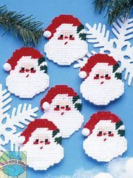 cross stitch christmas ornaments with santa's face and snowflakes on blue background