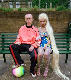 a man and woman sitting on a bench next to each other with long blonde hair