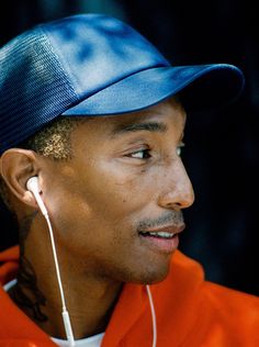 a close up of a person wearing ear buds and a cap with headphones in his ears