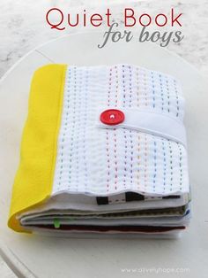 a quilted book sitting on top of a white table next to a red button