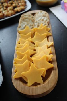 star shaped crackers on a wooden platter with other food items in the background