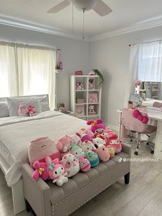 a bed with stuffed animals on it in a bedroom next to a desk and window