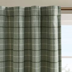 a window with green and white plaid curtains