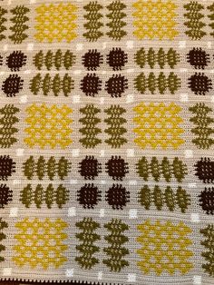 a close up of a knitted blanket with trees on it and dots in the middle