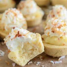 some desserts are sitting on a table with coconut flakes all over them and sprinkled with powdered sugar