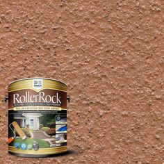 a paint bucket sitting on the ground next to a brown wall with some rocks in it