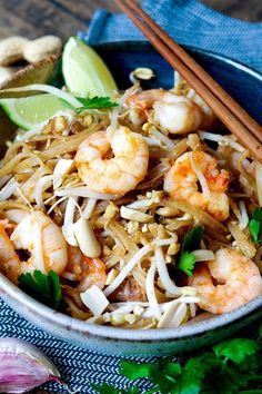 a bowl filled with shrimp and rice next to chopsticks