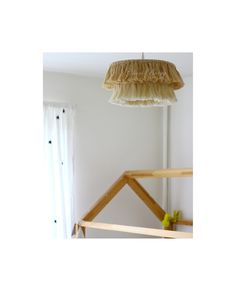 a lamp hanging from the ceiling in a room with white walls and wooden beams,