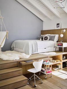 a loft bedroom with stairs leading up to the bed and storage space on the other side