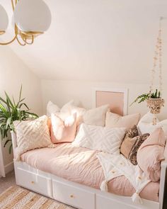 a white daybed with pink and gold pillows