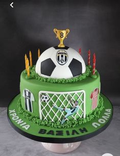 a soccer themed birthday cake with candles and a trophy on top for the ballon d'or winner