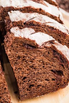 sliced loaf of chocolate bread sitting on top of a wooden cutting board