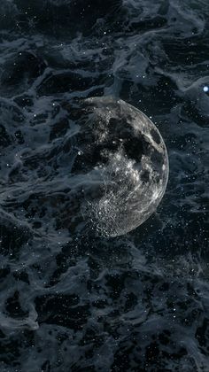 an image of the moon in the ocean with water splashing on it's surface