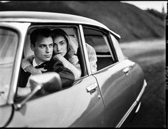 black and white photograph of two people in a car